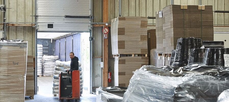 Logisticien déplaçant des marchandises dans l'entrepôt du siège